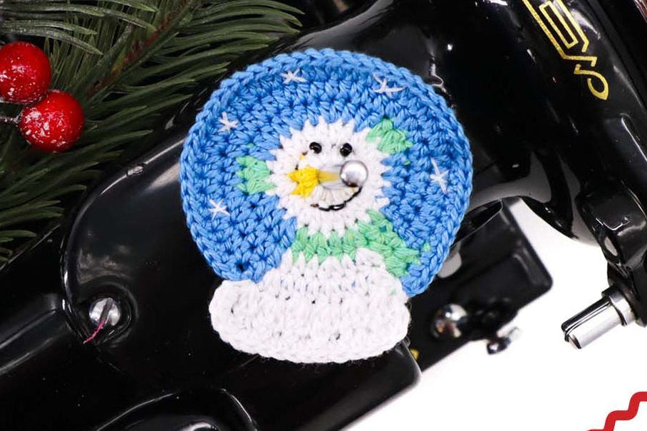 Snowman Snow Globe spool pin doily shown on the machine