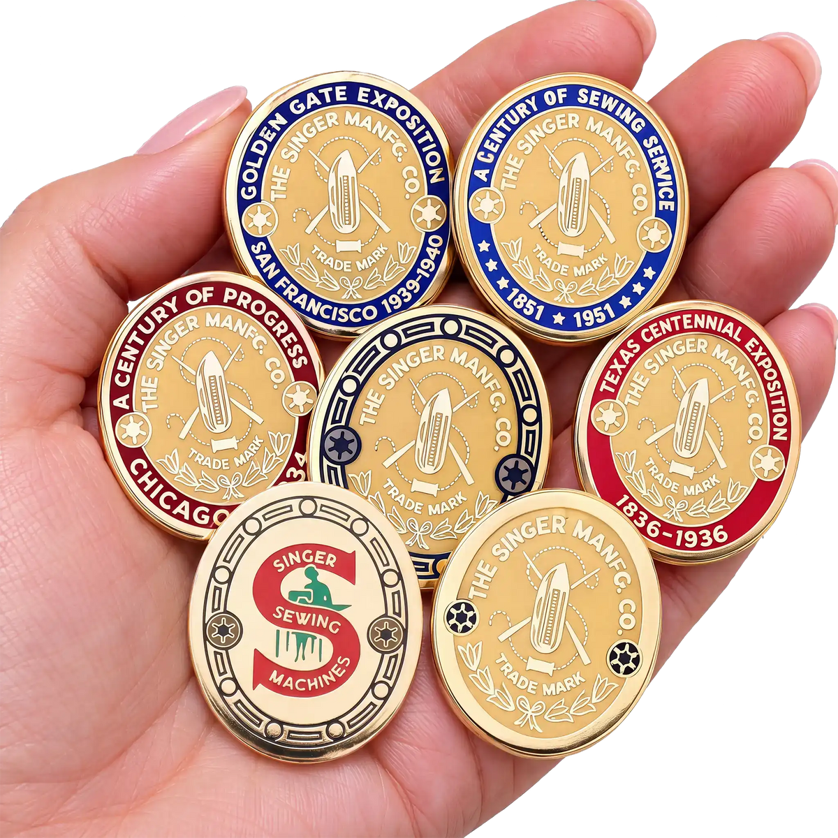 A hand holding all seven Featherweight badge Pin Pals.