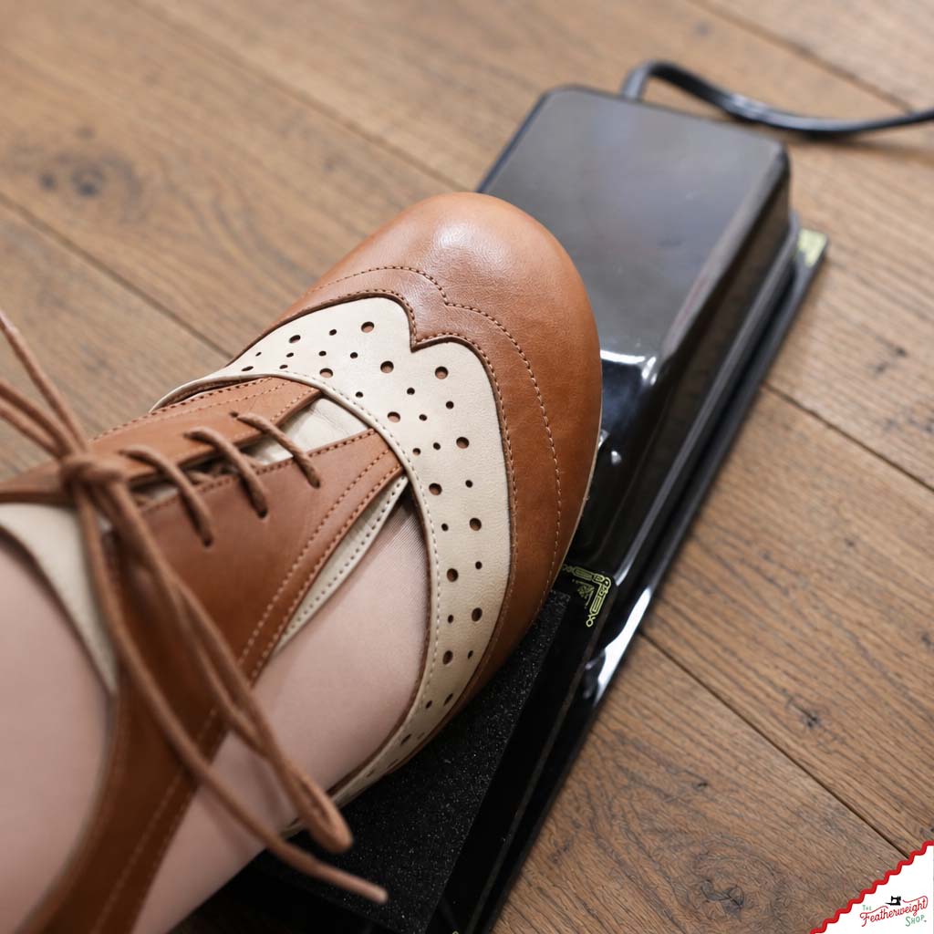 A shoe resting on the adaptor's anti-slip pad with the original foot pedal beneath.