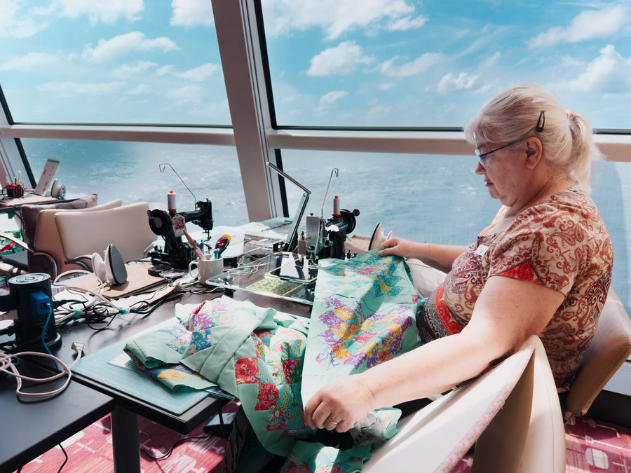 A quilter sewing beside a sea-view window