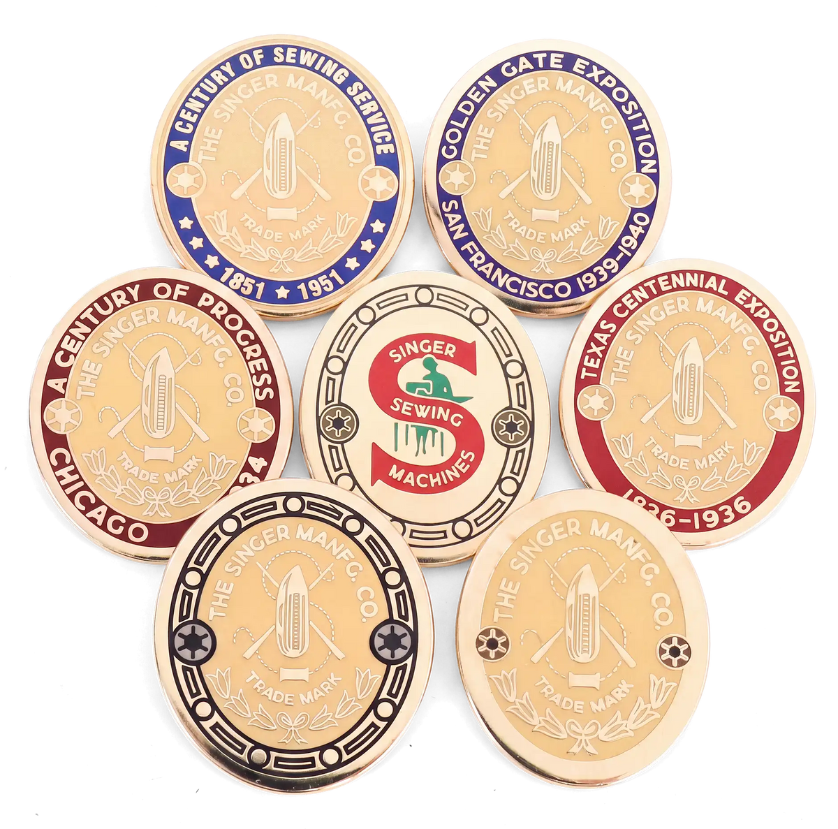 All seven Featherweight badge Pin Pals arranged together: Chicago 1934, Texas Centennial, Golden Gate, Singer Centennial, Standard Gold, Red S and Black Border.