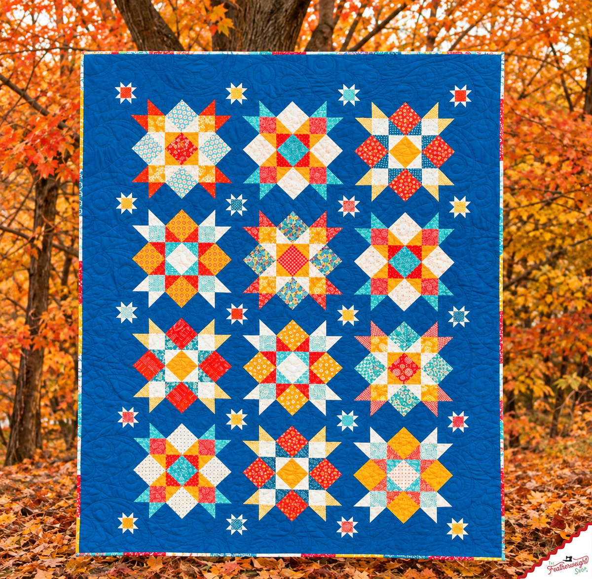 Finished Summer Picnic quilt in Lori Holt's Americana fabrics, hung in autumn trees