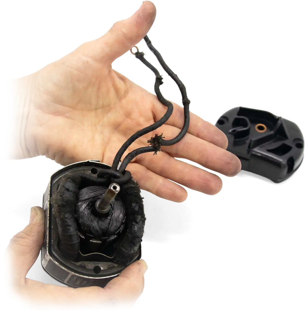 Hands holding an opened Featherweight motor, its worn original armature and frayed old wiring inside