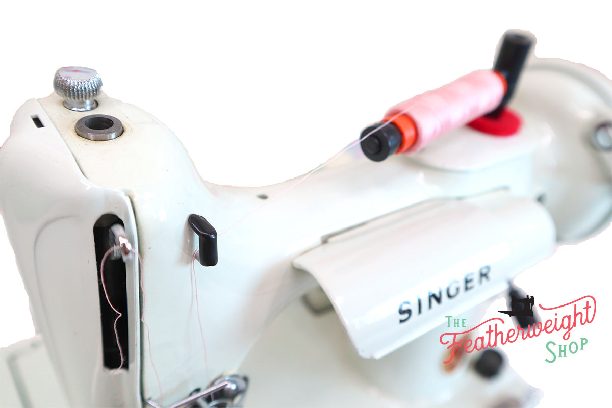 Vintage Singer sewing machine threaded with spool of white thread